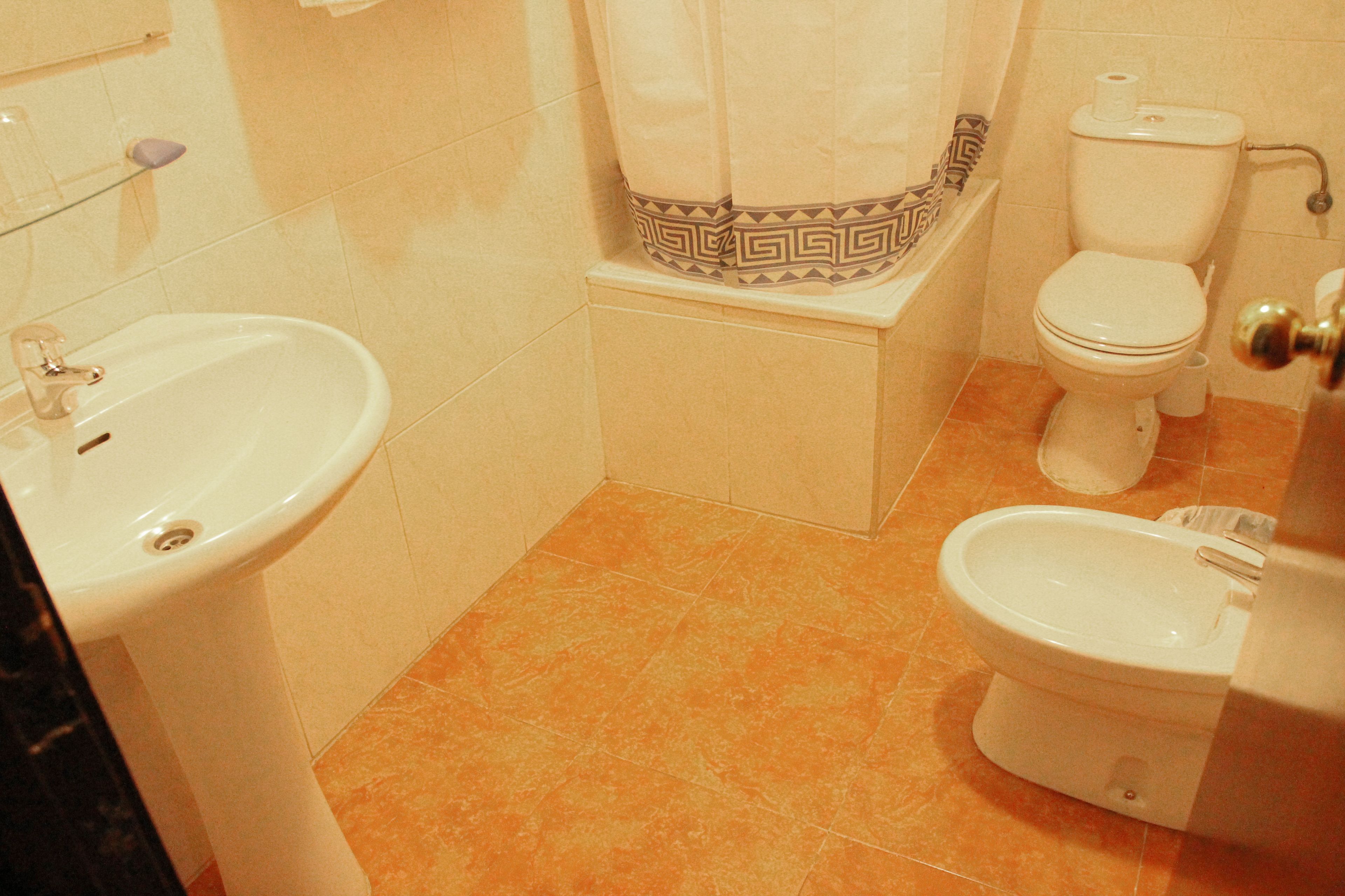 Een badkamer met een wastafel, toilet en bidet.