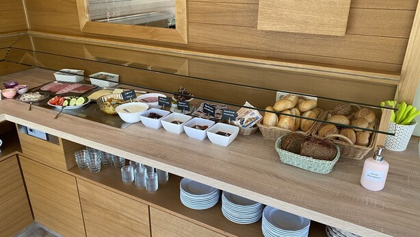 A buffet counter with various food items and condiments. - Hotel Pension Kühne (Boltenhagen)