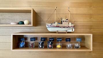 A wooden wall with shelves displaying various kitchen items and a model boat.