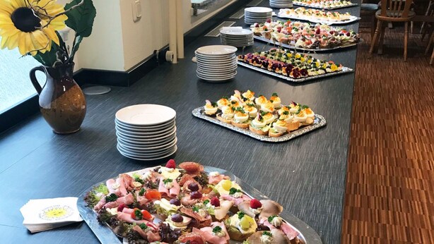 Una mesa de buffet con diferentes alimentos y un jarrón de girasoles.
