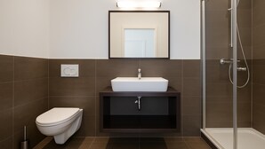 A modern bathroom with a toilet, sink, and shower. - Wilhelmshaven Ahoi, Sure Hotel Collection by Best Western (Wilhelmshaven)