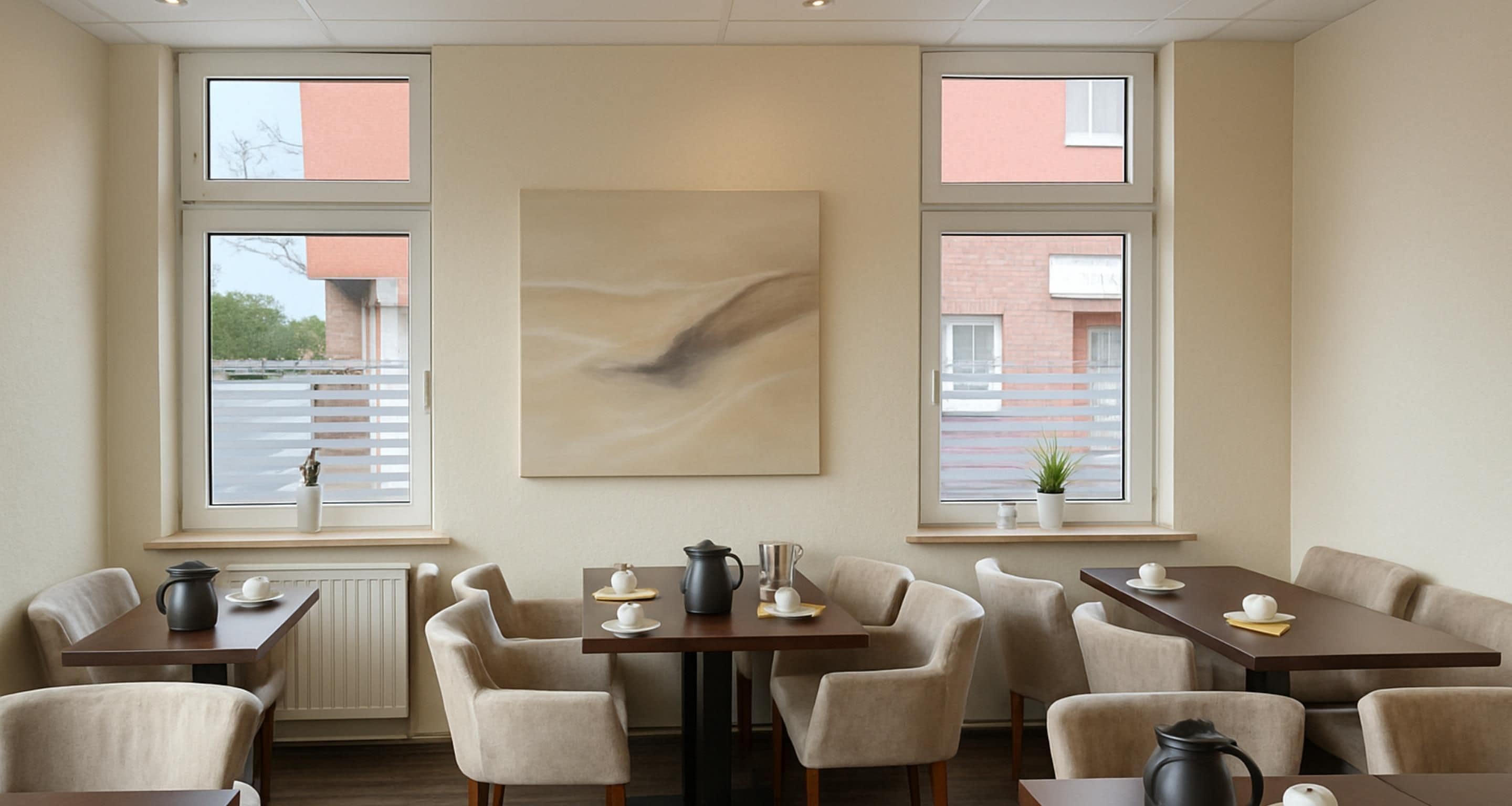 A modern dining area with tables and chairs, large windows, and a central abstract painting.