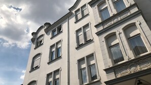 Un edificio de varios pisos con amplias ventanas y detalles arquitectónicos decorativos.