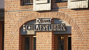 A brick building with a sign reading "Exempel Schlaftuben".