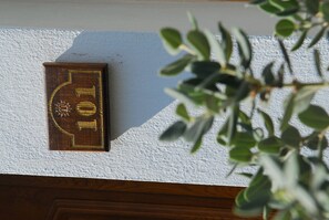 A wooden plaque with the number 101 on a white wall. - Apollo City (Hersonissos)