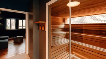 Un interior moderno con una sauna de madera, un separador de vidrio y un área de descanso con vistas al exterior.