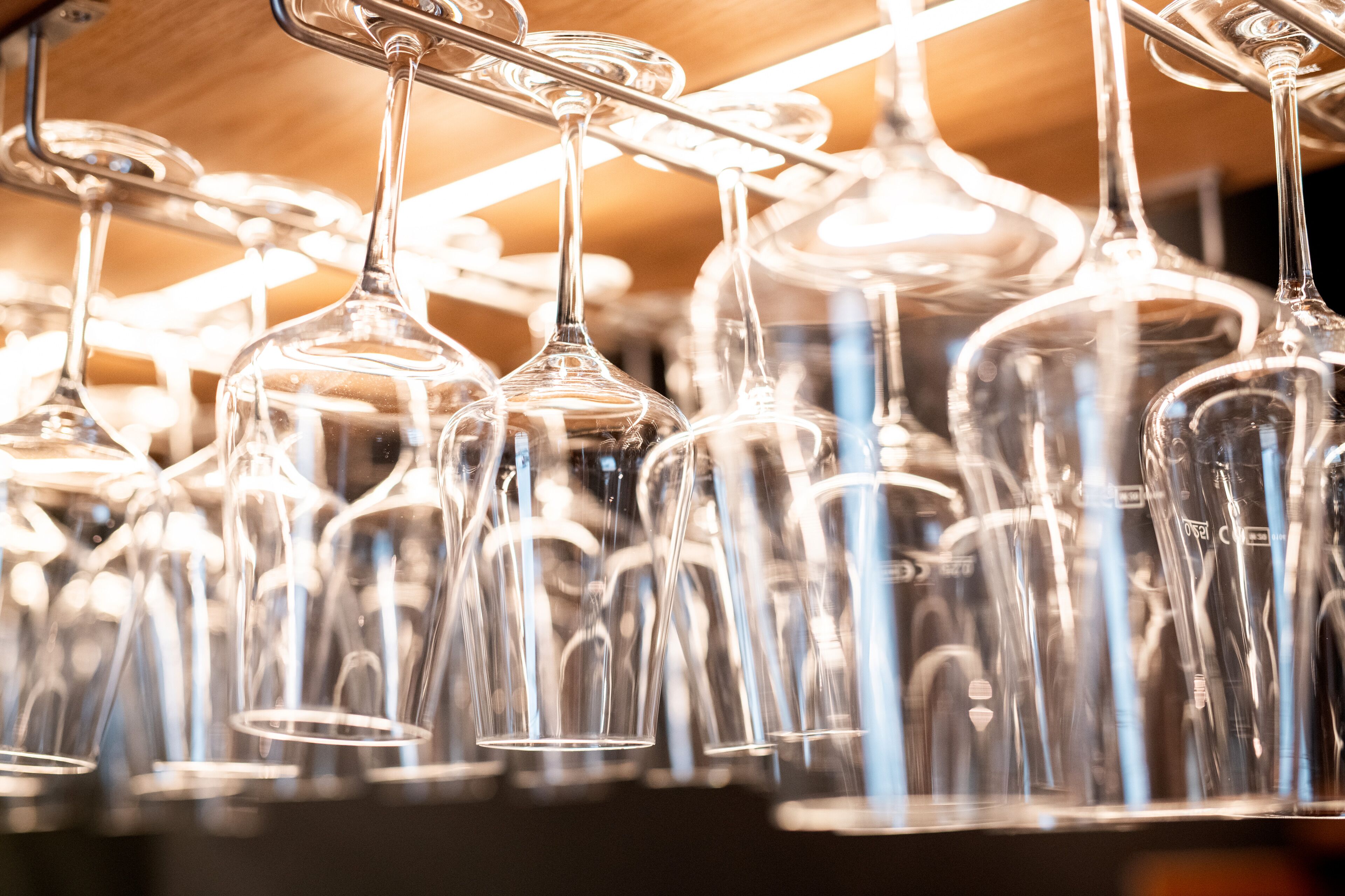 A collection of wine glasses suspended from a ceiling.