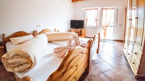 A bedroom with a wooden bed, a television, and a wardrobe. - Landgasthof Scherer (Wenden)