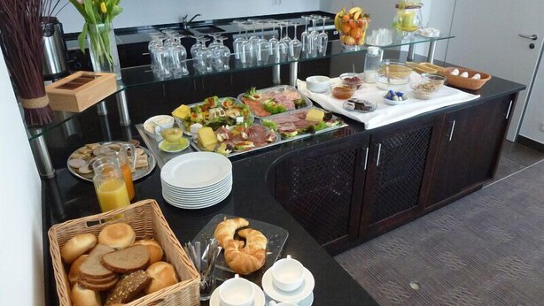 Un dispositiu de buffet amb diversos plats, vidrieres i un ram de flors.