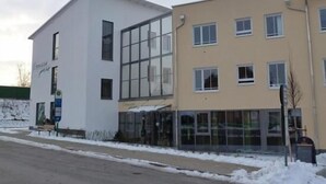 Edifici modern amb façana de vidre i teulat pla.