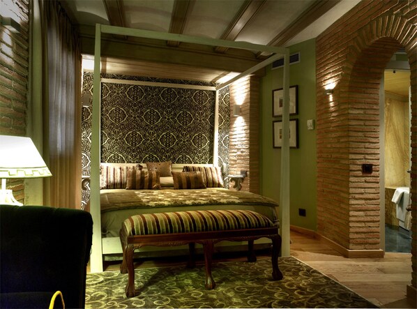 Un dormitorio con cama con dosel, papel tapiz estampado y pared de ladrillo.