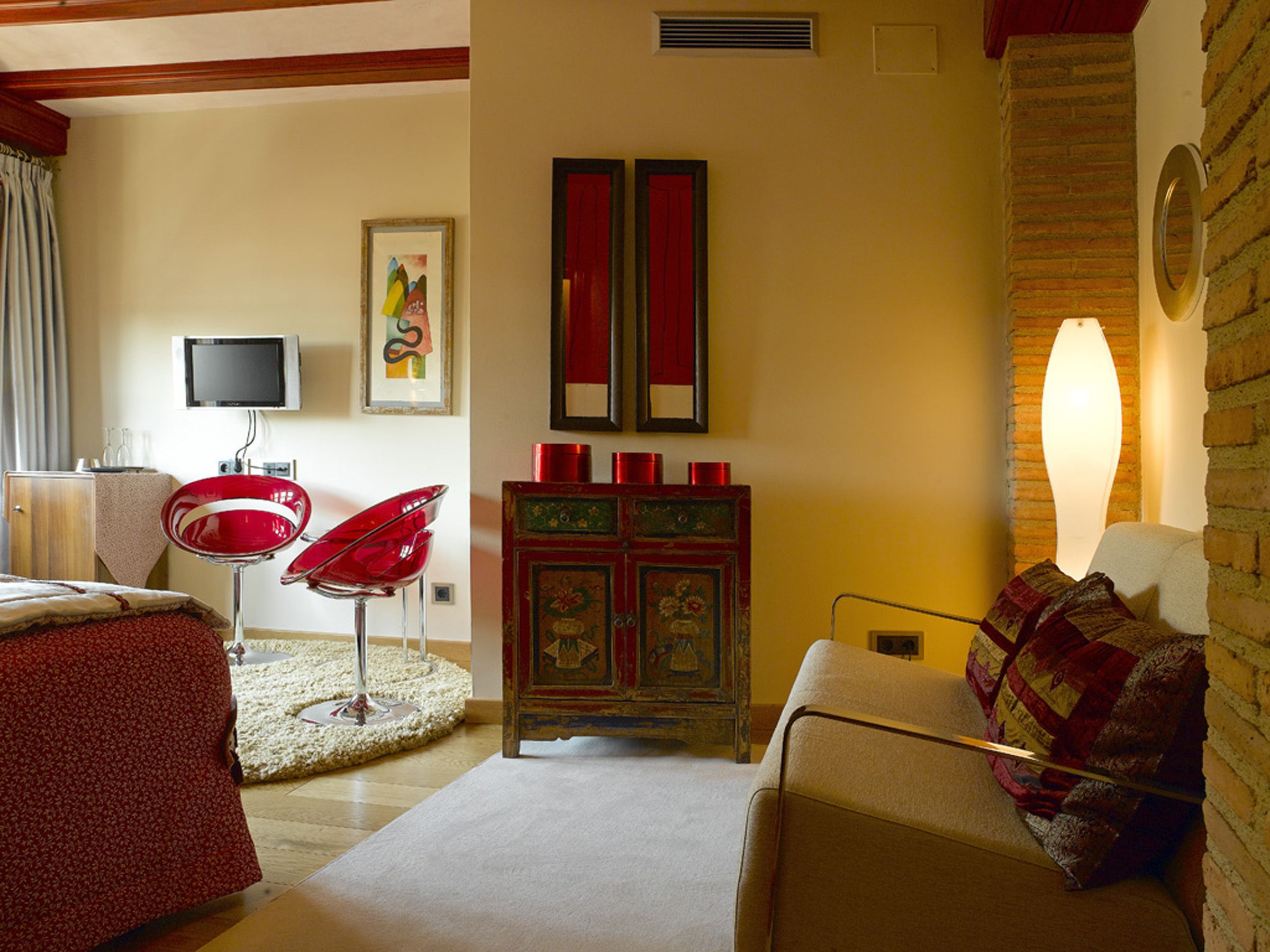 Una sala de estar acogedora con un sillón rojo, un sofá, una chimenea y un televisor.