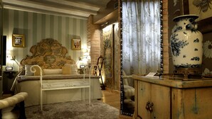 Una habitación clásica con cama con dosel, un armario de madera y un jarrón grande.
