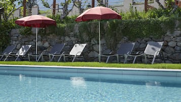 Outdoor pool, an infinity pool, pool umbrellas, pool loungers