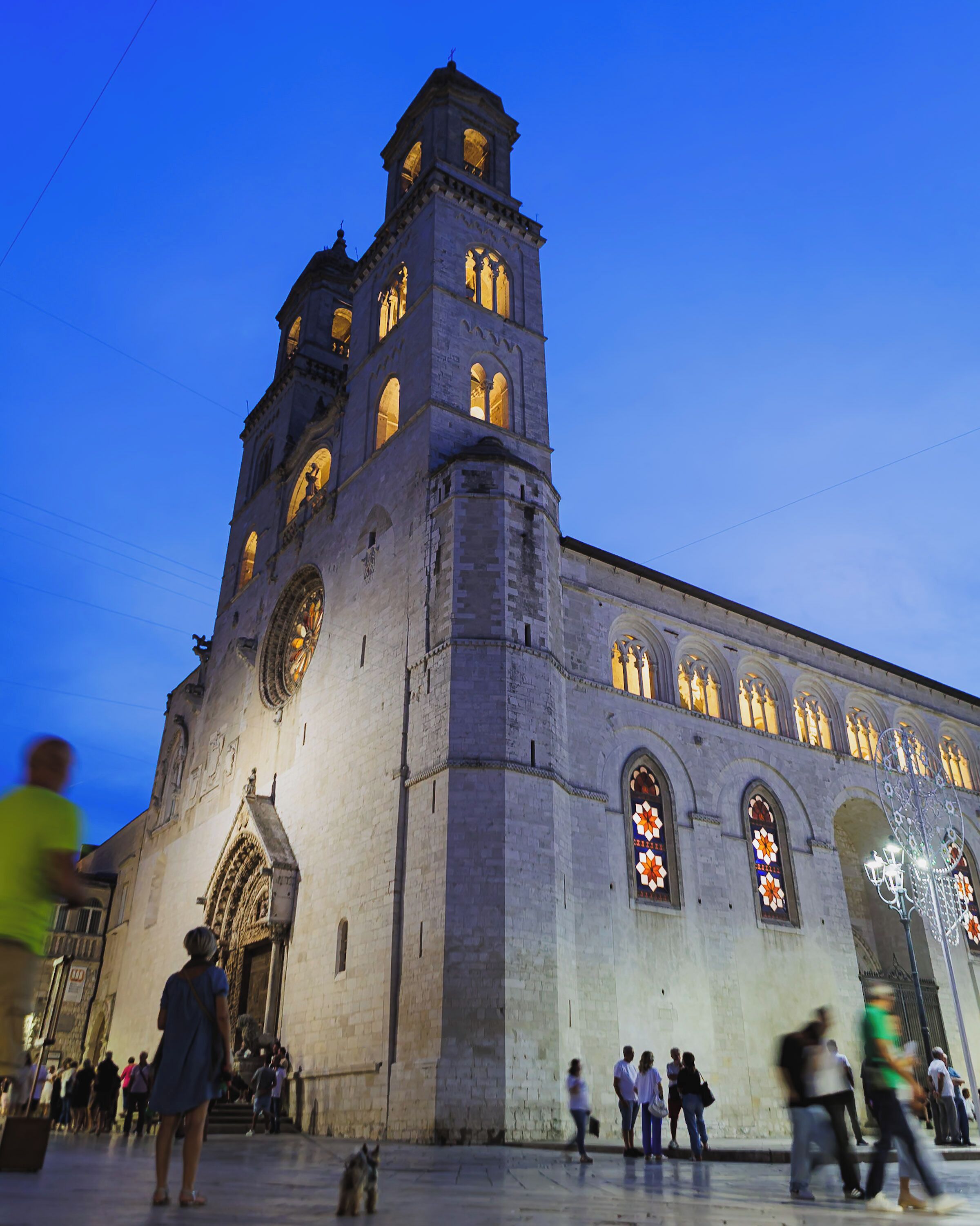 A historic church with a prominent bell tower and large stained glass windows.