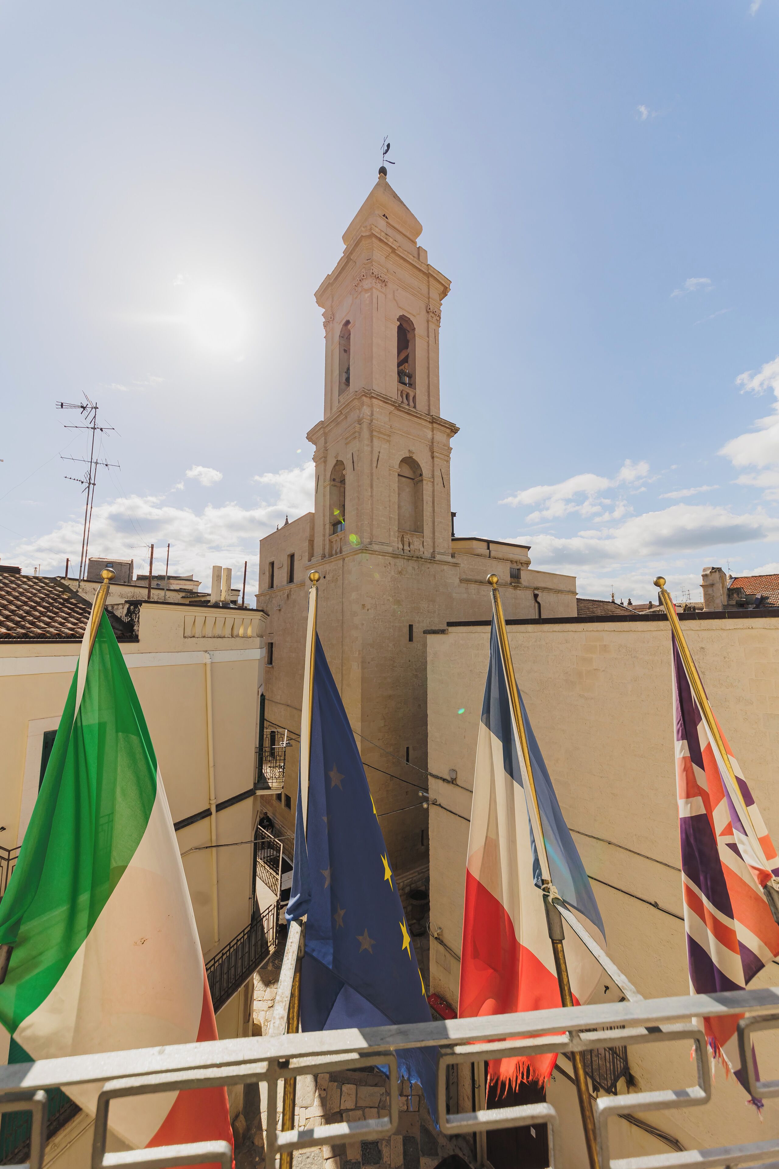 A building with a bell tower, surrounded by flags.