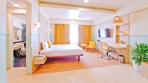 A hotel room with a bed, a desk, a chair, a TV, and a plant. - Bloom Hotel - Indiranagar  (Bengaluru)