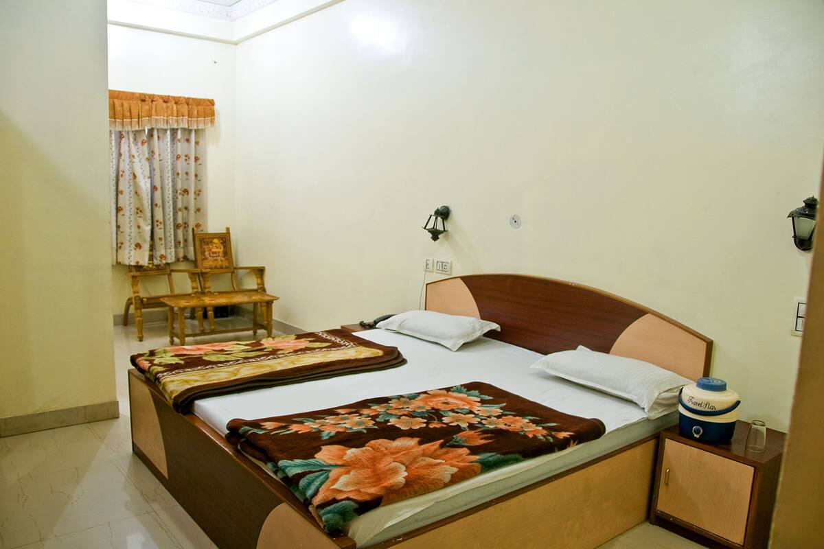 A neatly arranged bedroom with a bed, bedside table, and a chair.