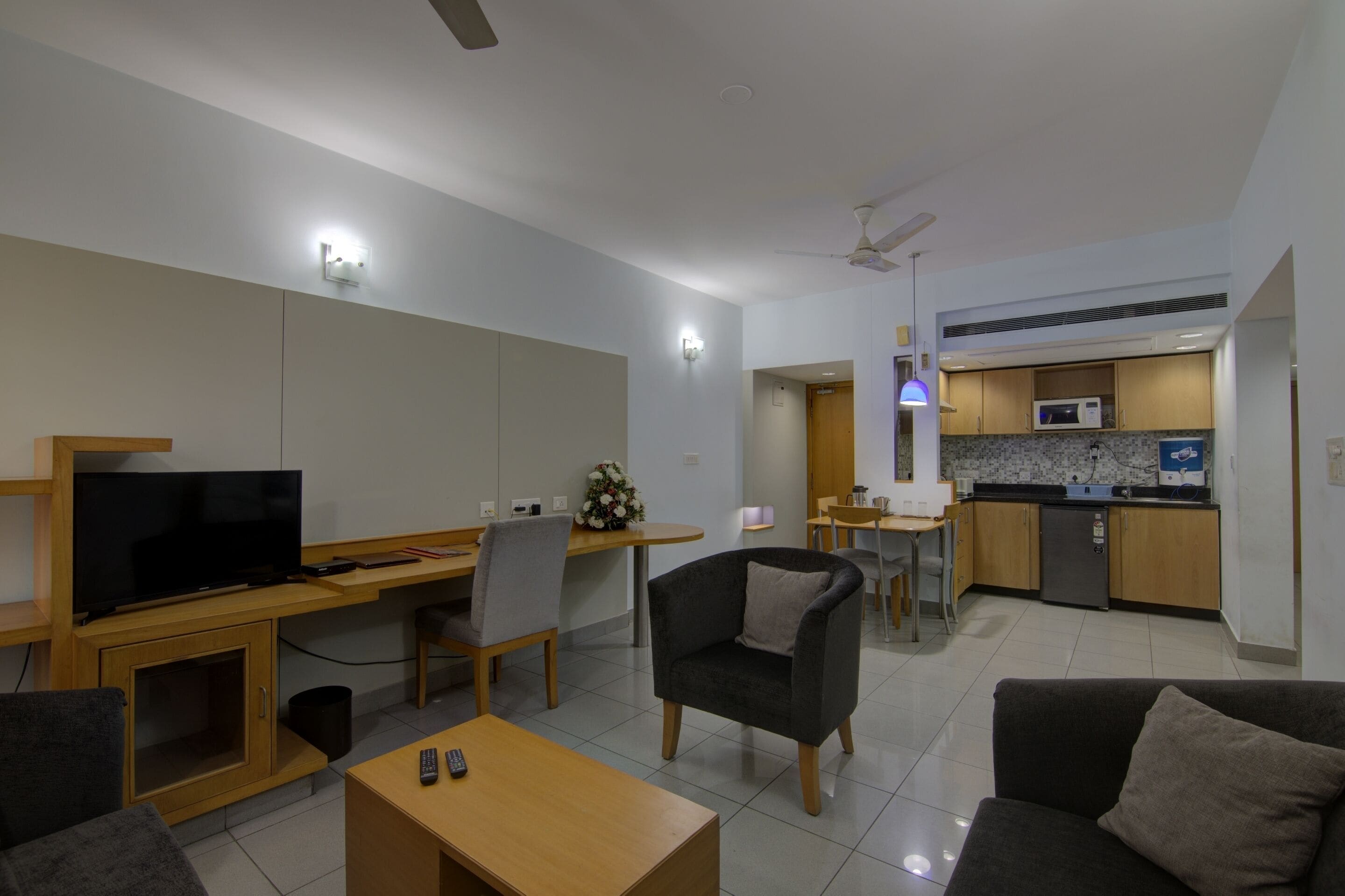 A modern living room with a television, sofa, and dining area.