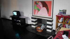 A room with a fireplace, a television, and a bookshelf. - Romeo and Juliet B&B and Apartaments (Bergamo)