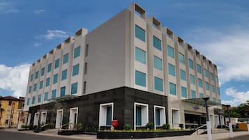 Een modern hotel met een symmetrische gevel, veel ramen en een centrale ingang met treden.