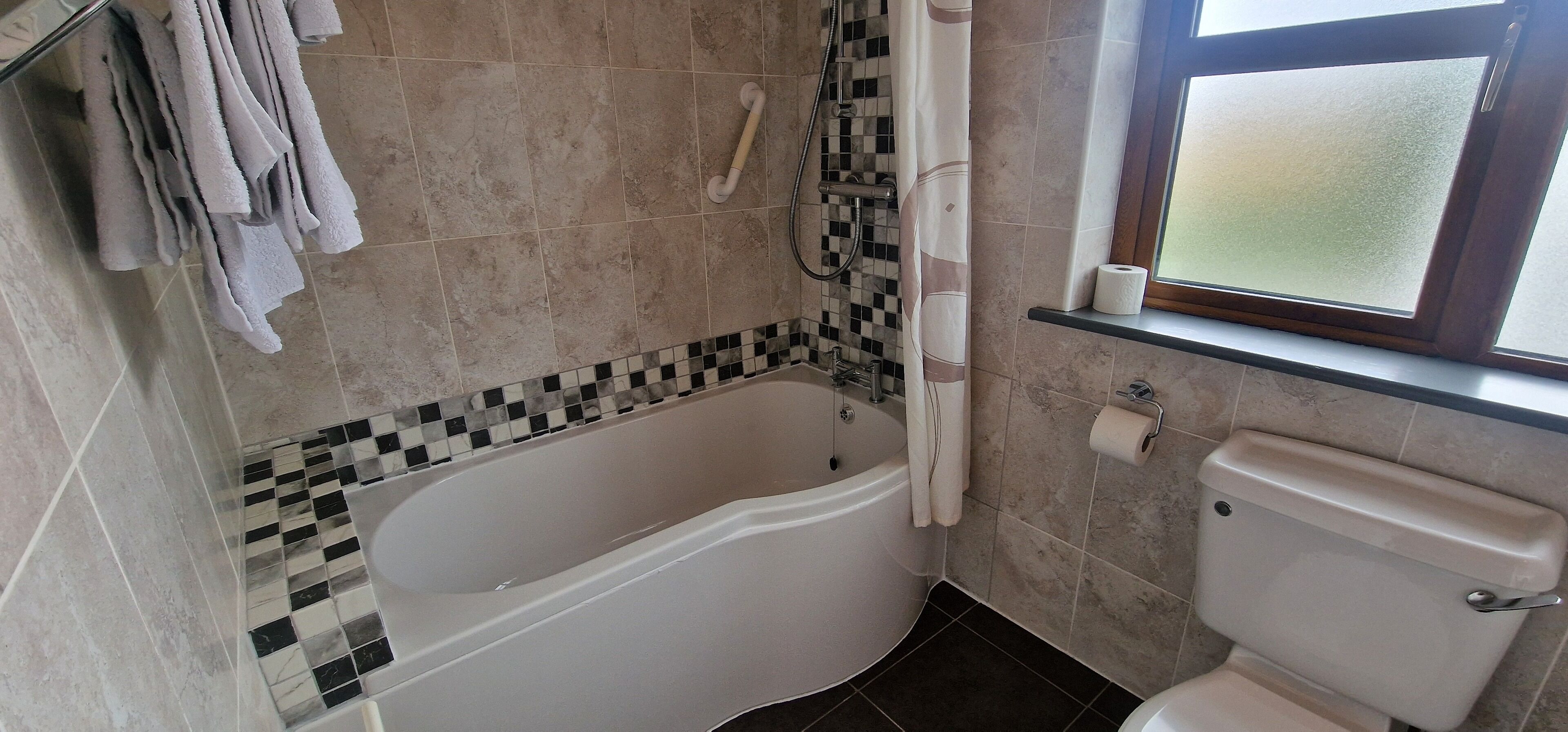 Un bagno con vasca, water e doccia.