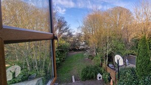 A garden with a wooden fence, a white birdhouse, and a satellite dish. - Church View B&B (Gurteen)