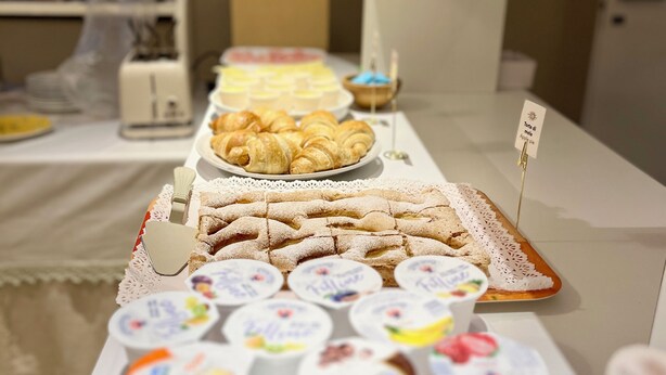 A buffet table with various food items including pastries, desserts, and yogurt. - Eremes Rooms & Apartments (Cuneo)