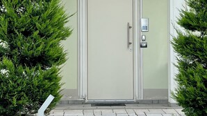 A house with a light green exterior, a white door with a number '59' above it, and a keypad lock on the right side. - Eremes Rooms & Apartments (Cuneo)