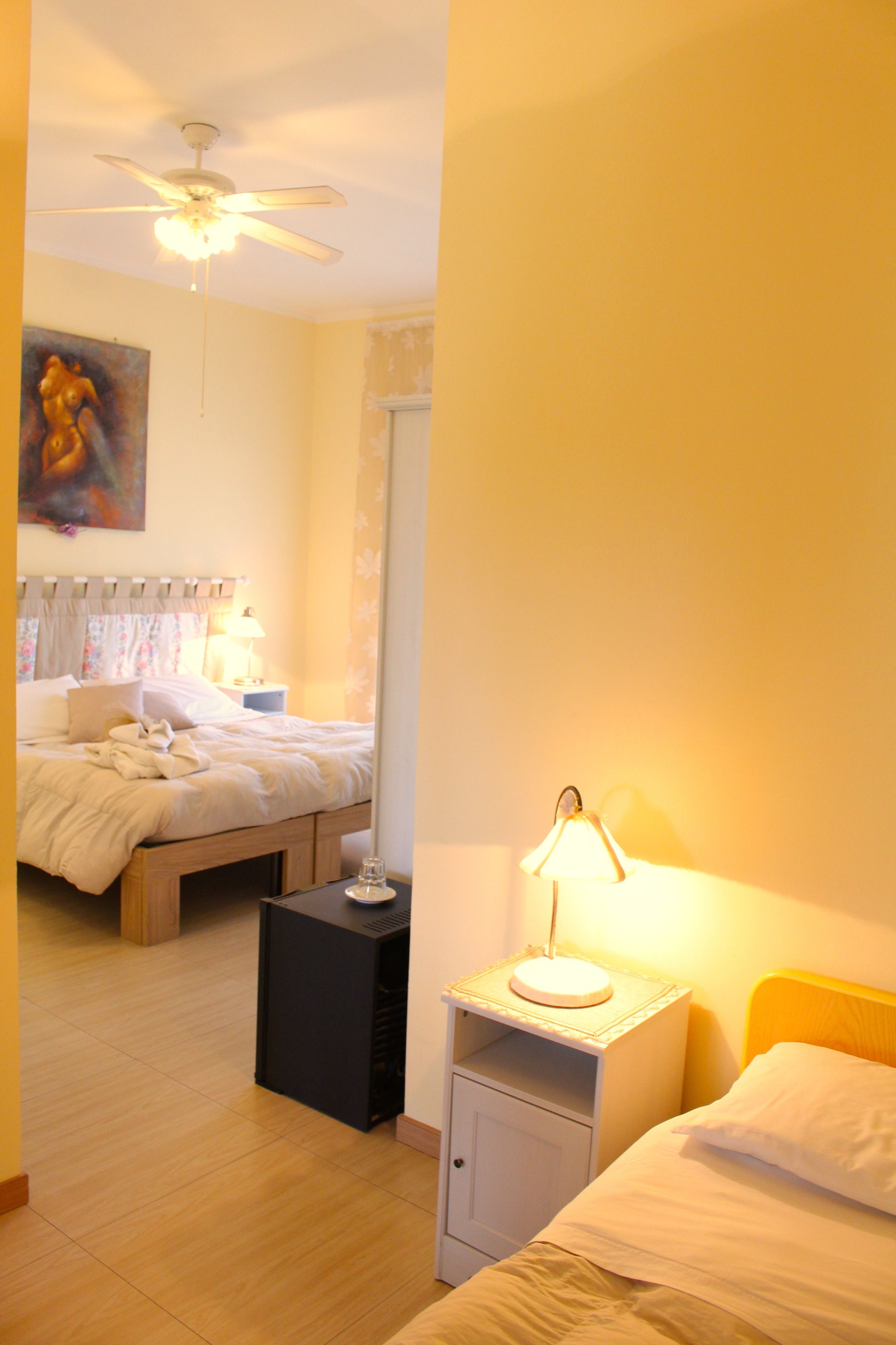 Une chambre d’hôtel équipée d’un lit, d’une table de chevet, d’une lampe et d’un ventilateur de plafond.