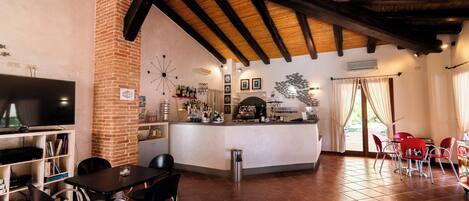 Amplia sala de estar con chimenea, barra y televisor.