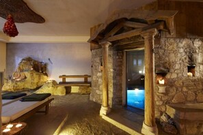 A spa area with stone walls, wooden beams, and a bench. - Ai Cadelach Hotel Giulia (Revine Lago)