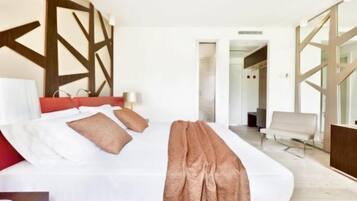 A modern hotel room with a large bed, a red headboard, and a wooden wall design.