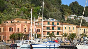 Ein Yachthafen mit vertäuten Booten, ein Hotel mit Balkonen und Gebäude mit Balkonen mit Blick auf das Wasser.
