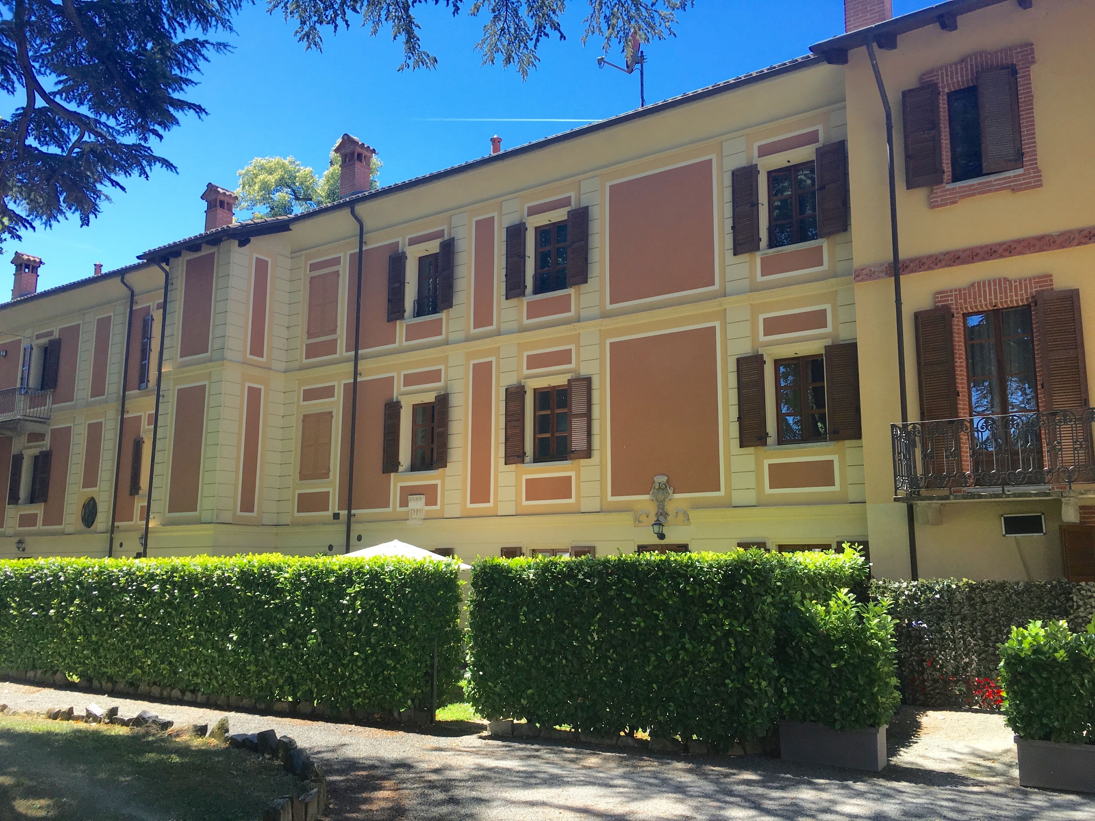 A multi-story building with a symmetrical facade, featuring evenly spaced windows and shutters.