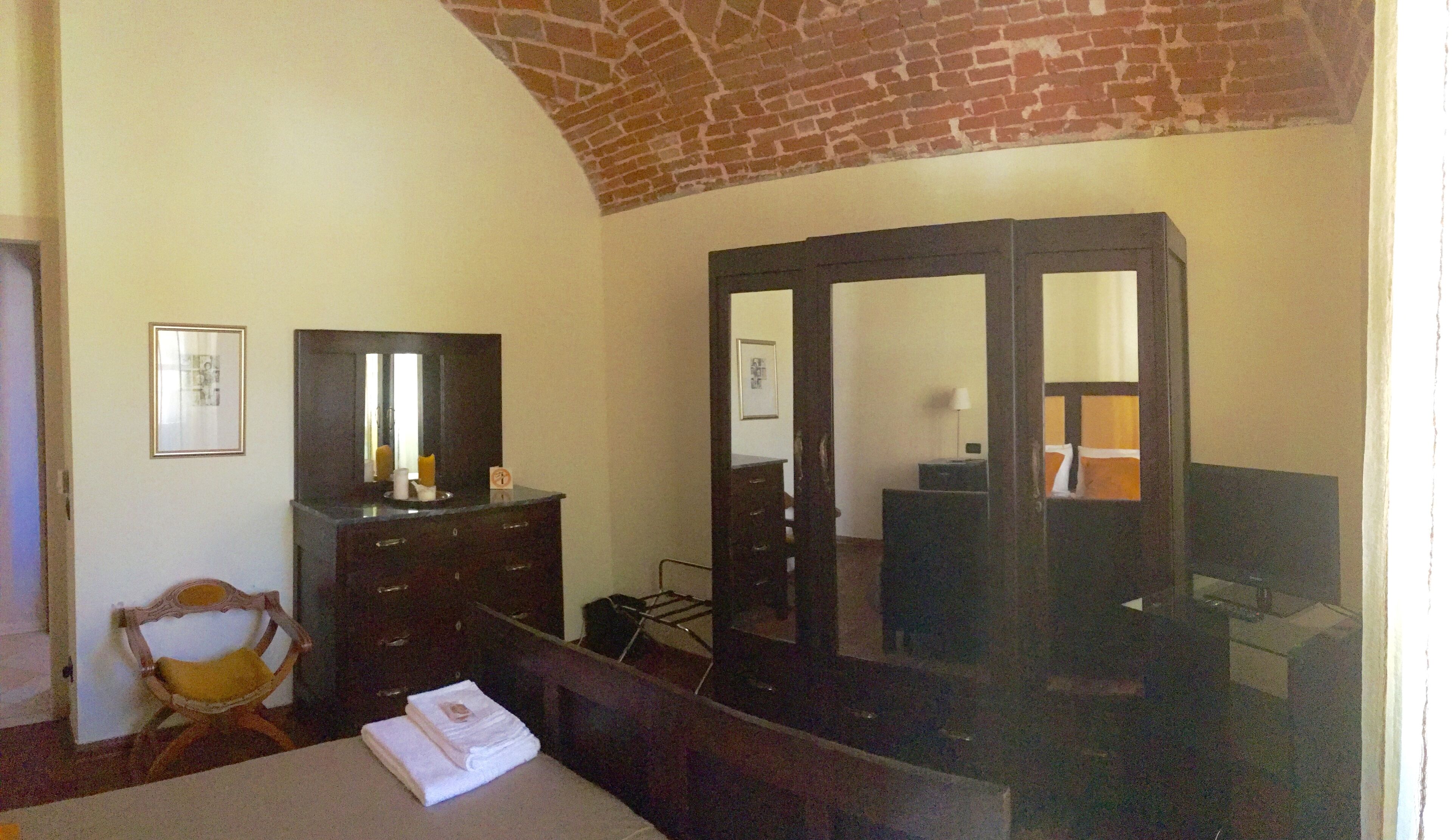A room with a bed, a dresser, a mirror, and a chair.