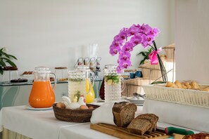 A breakfast buffet with various food items, including bread, pastries, and a pitcher of orange juice. - Hotel delle Nazioni (Pesaro)