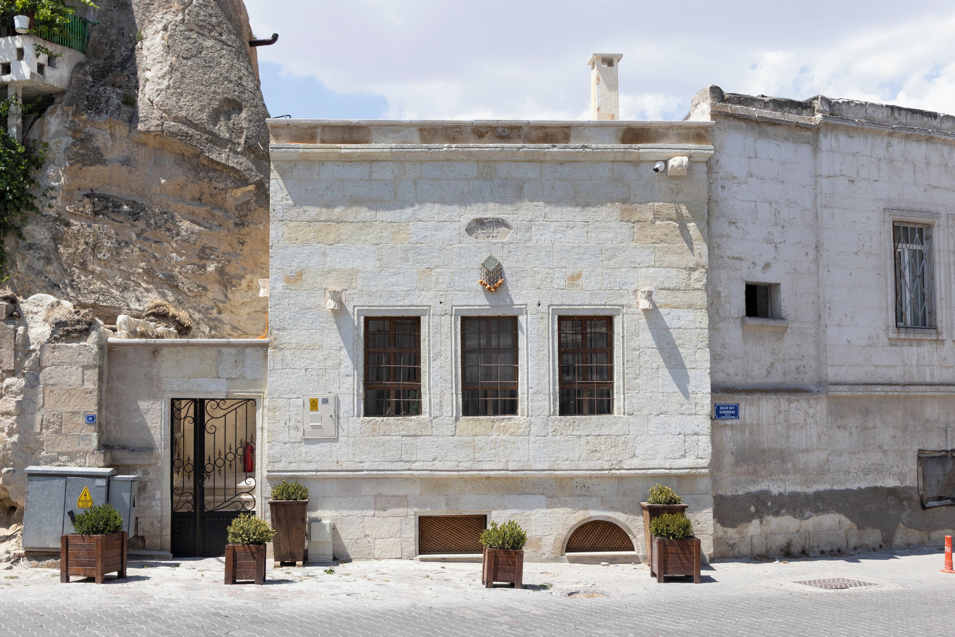 A historic building with a stone facade, three windows, and a door.