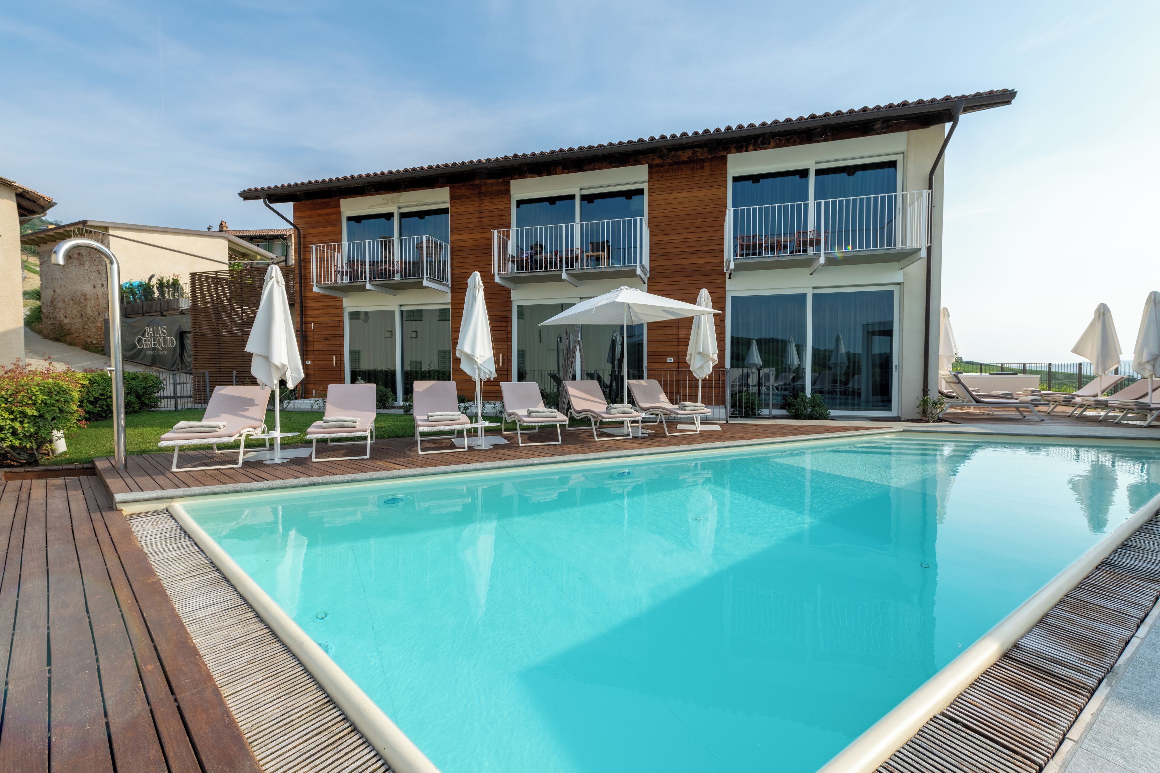 Una piscina al aire libre, sombrillas, tumbonas