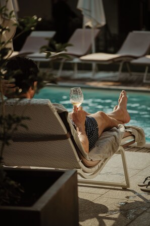 Alberca al aire libre, sombrillas en la alberca y camastros 