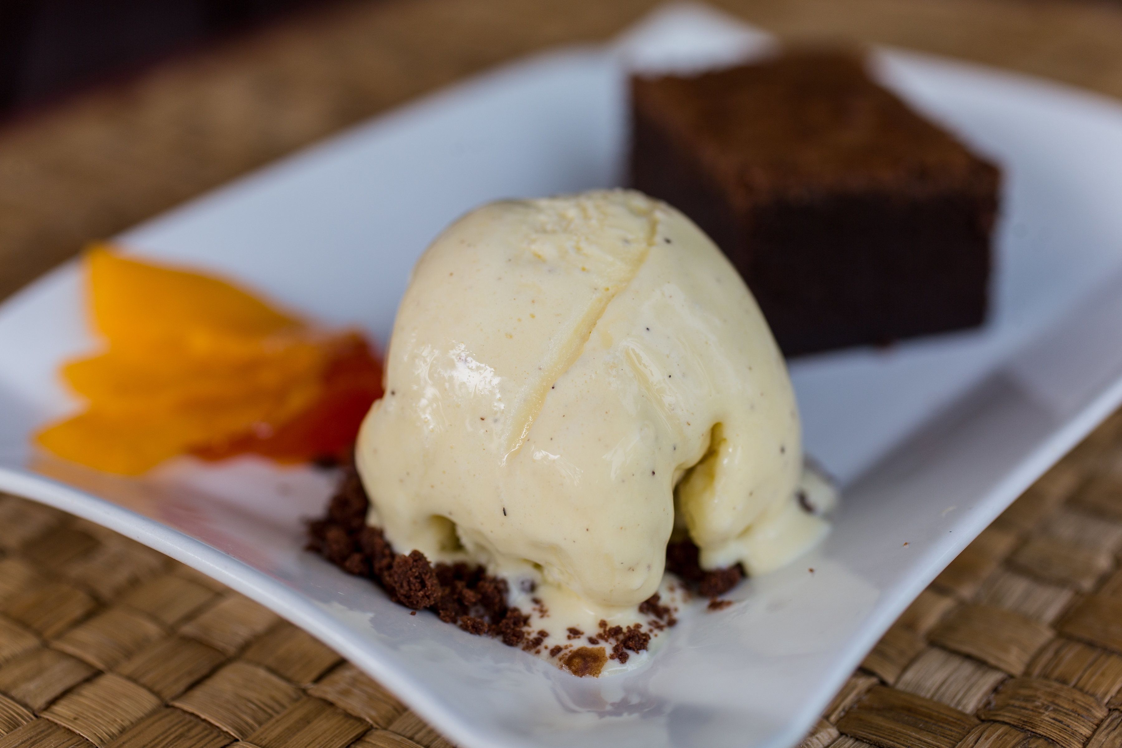 A dessert plate with a scoop of vanilla ice cream and a piece of chocolate cake.