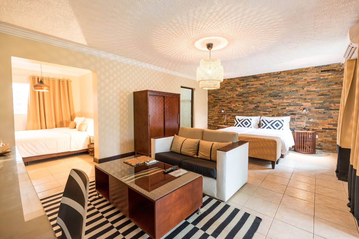 Ein modernes Hotelzimmer mit Bett, Sofa und Couchtisch.