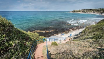 Playa privada, sillas reclinables de playa, sombrillas