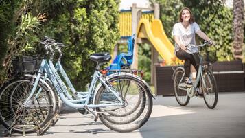 Uma bicicleta estacionada perto de um parquinho com um escorrega.