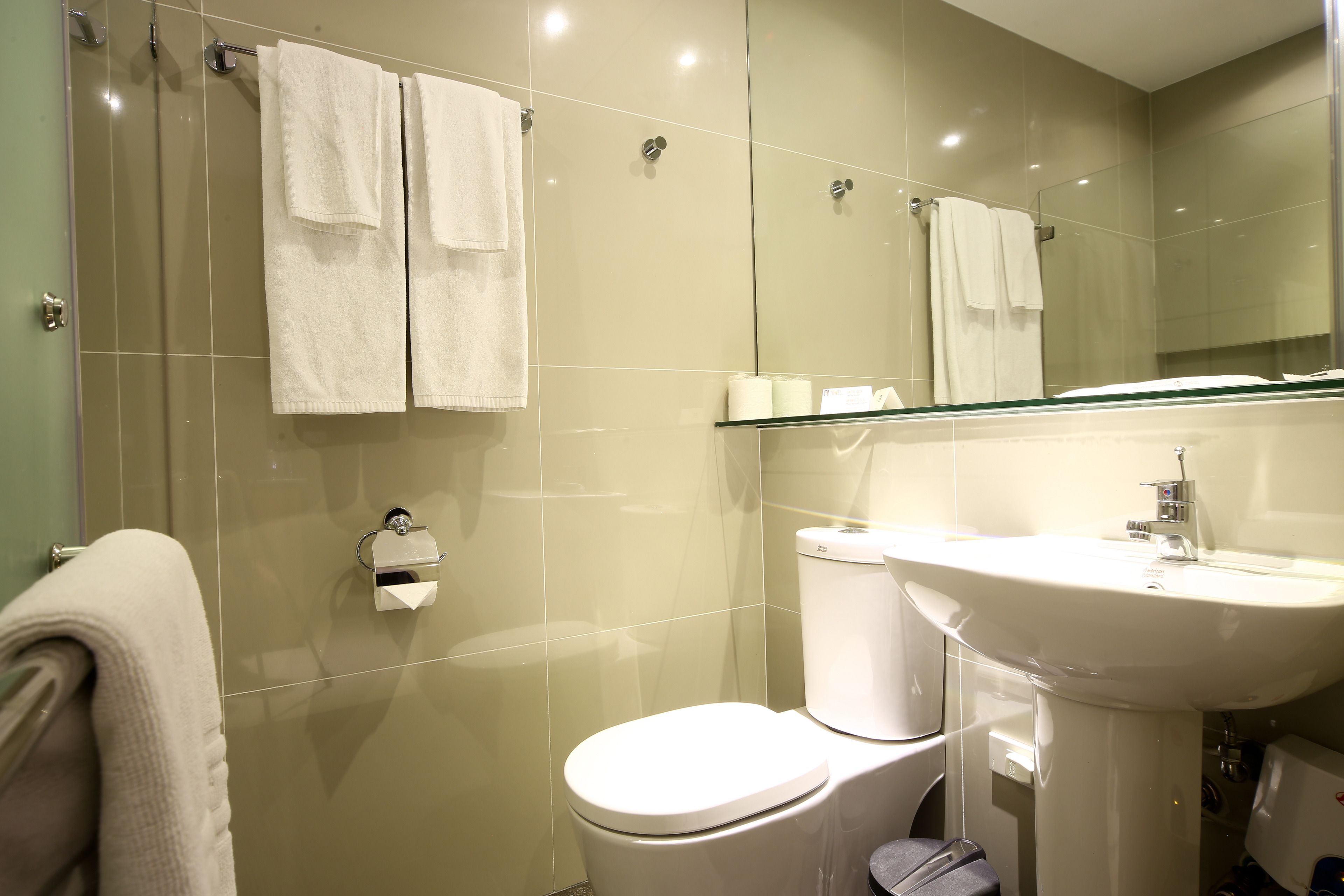 A modern bathroom with a toilet, sink, and glass shower enclosure.