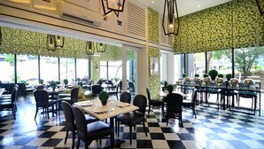 A restaurant with a checkered floor, tables with chairs, and green patterned wallpaper. - Azumi Boutique Hotel (Muntinlupa)