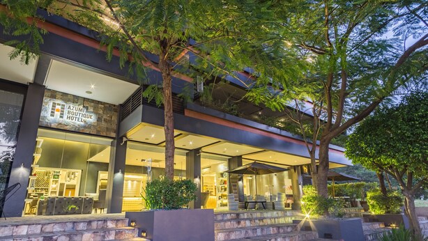 A modern hotel with a stone facade, outdoor seating, and a well-lit entrance. - Azumi Boutique Hotel (Muntinlupa)