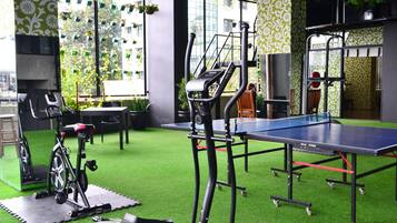 Stay active and relaxed in our well-equipped indoor recreational area featuring a stationary exercise bike, treadmill, and ping pong table.