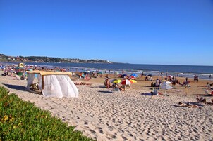Ubicación cercana a la playa, arena blanca y toallas de playa