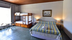 A room with a bunk bed, a single bed, a desk, and a chair. - Hotel da Canoa (Arraial do Cabo)